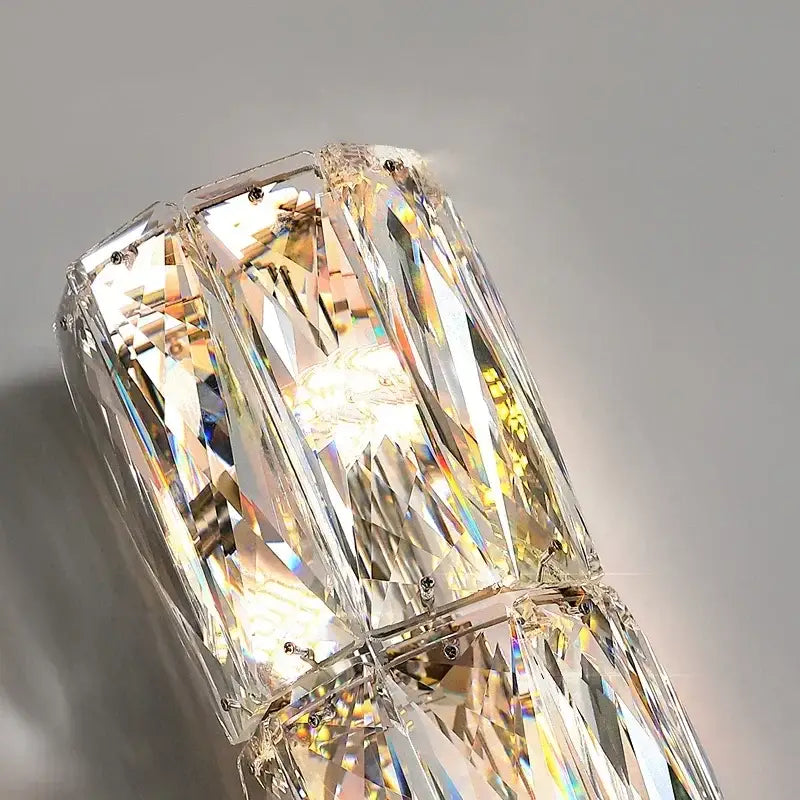 Modern chrome crystal wall light with faceted clear glass prisms in a geometric pattern for luxury living room decorbites sconce