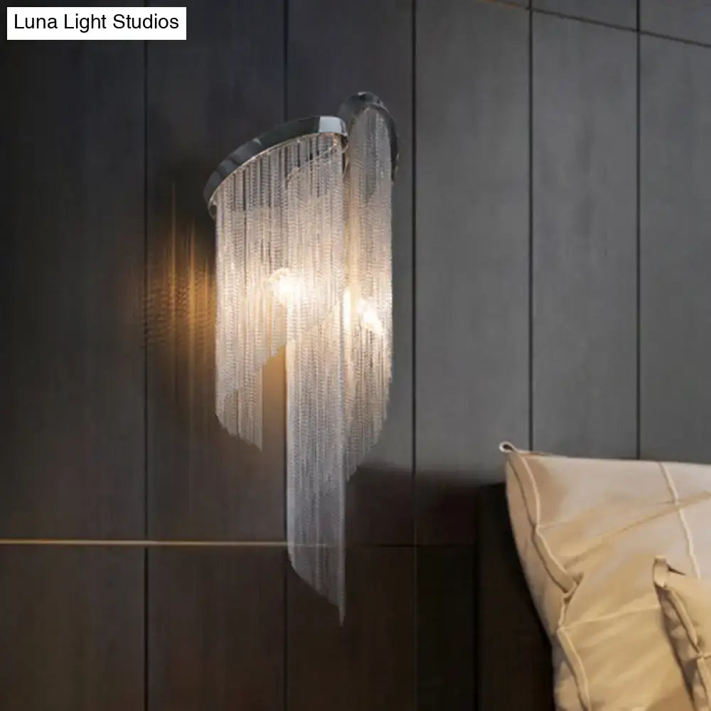 Modern chrome crystal wall sconce with curved base and cascading clear beads for bedroom bedside lighting