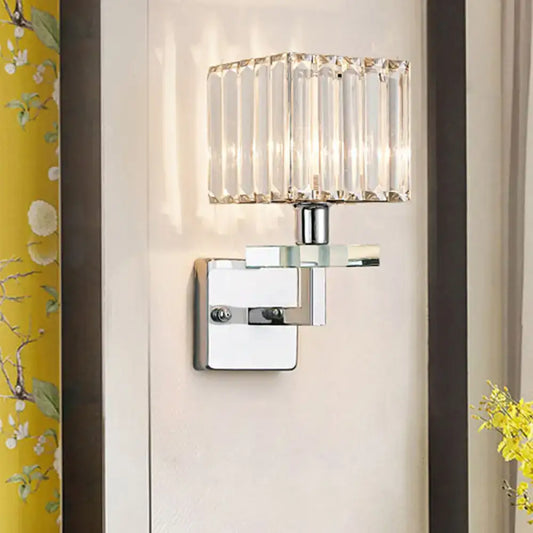 Modern chrome cuboid crystal wall mounted light with faceted glass shade and polished metal base for bedroom use