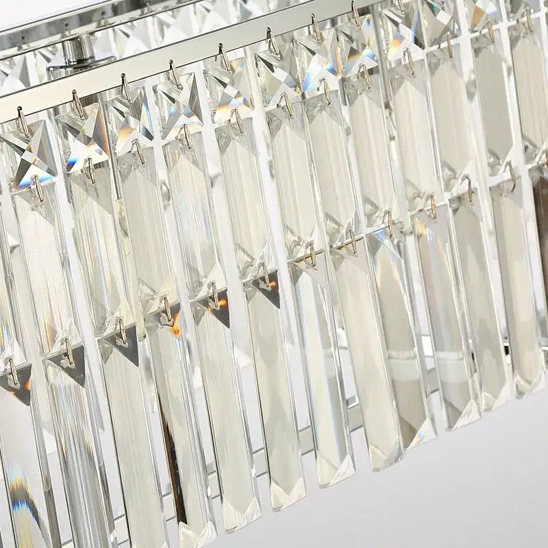 A modern chrome decorbites crystal chandelier with clear faceted rectangular prisms for dining room lighting