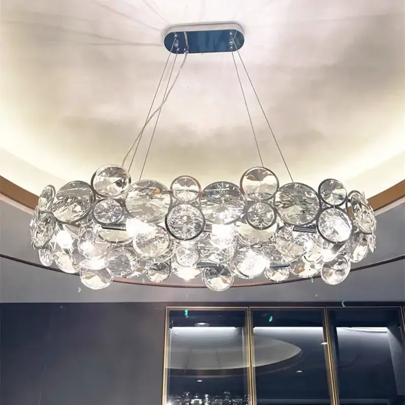 A modern chrome decorbites crystal led chandelier with clear faceted discs for dining room lighting