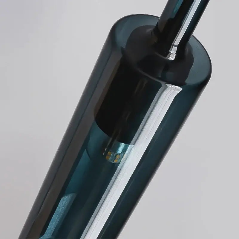 A sleek dark teal glass pendant with polished finish and led light bulb in modern chrome decorbites glass chandeliers
