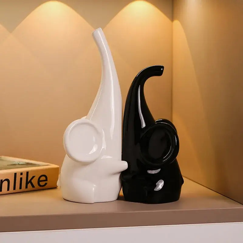 A sleek glossy white and black ceramic elephant sculpture bookend for modern living room decor by decorbites