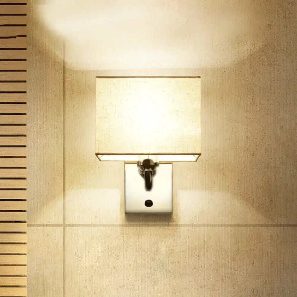 Modern square-shaped fabric led wall sconce with beige linen shade and polished chrome base for bedroom lighting