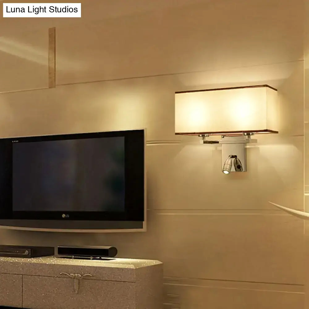 Modern chrome fabric led wall sconce with white shade and metallic frame emitting warm glow for bedroom lighting fixture