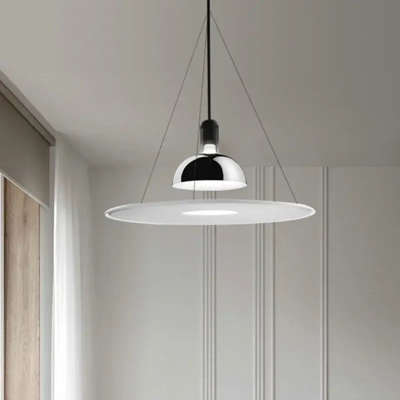 Modern chrome flying saucer chandelier with a sleek chrome dome and white shade suspended by black cords for living room lighting