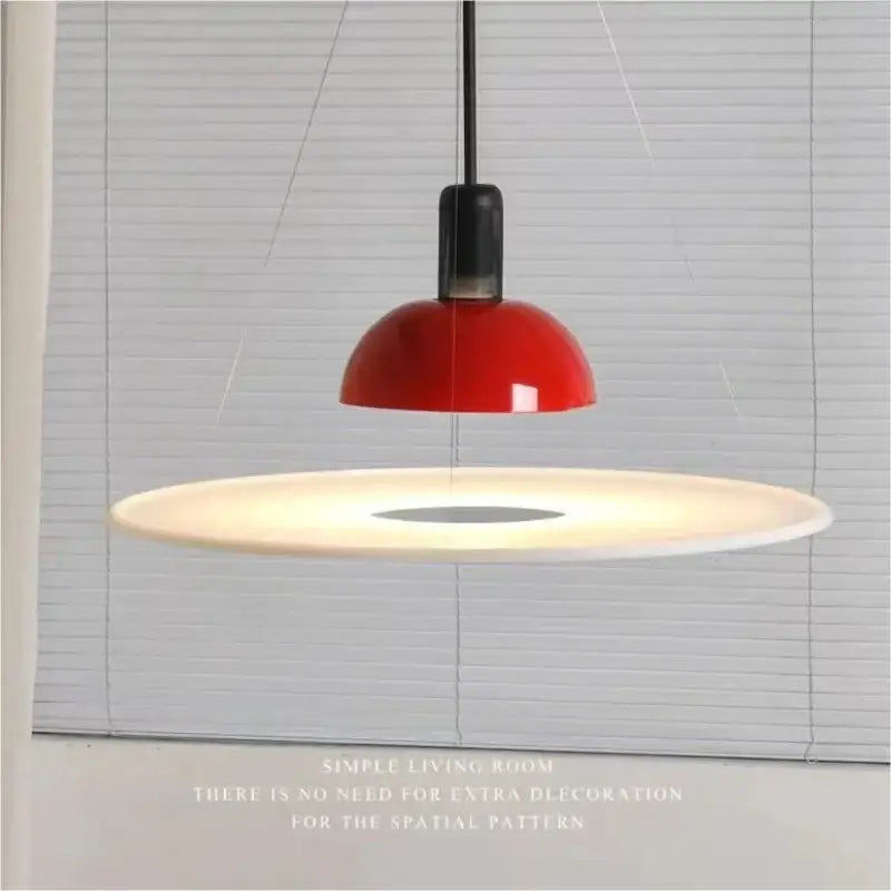 A modern flying saucer chandelier with a glossy red dome shade, white diffuser, and black cord for living room lighting