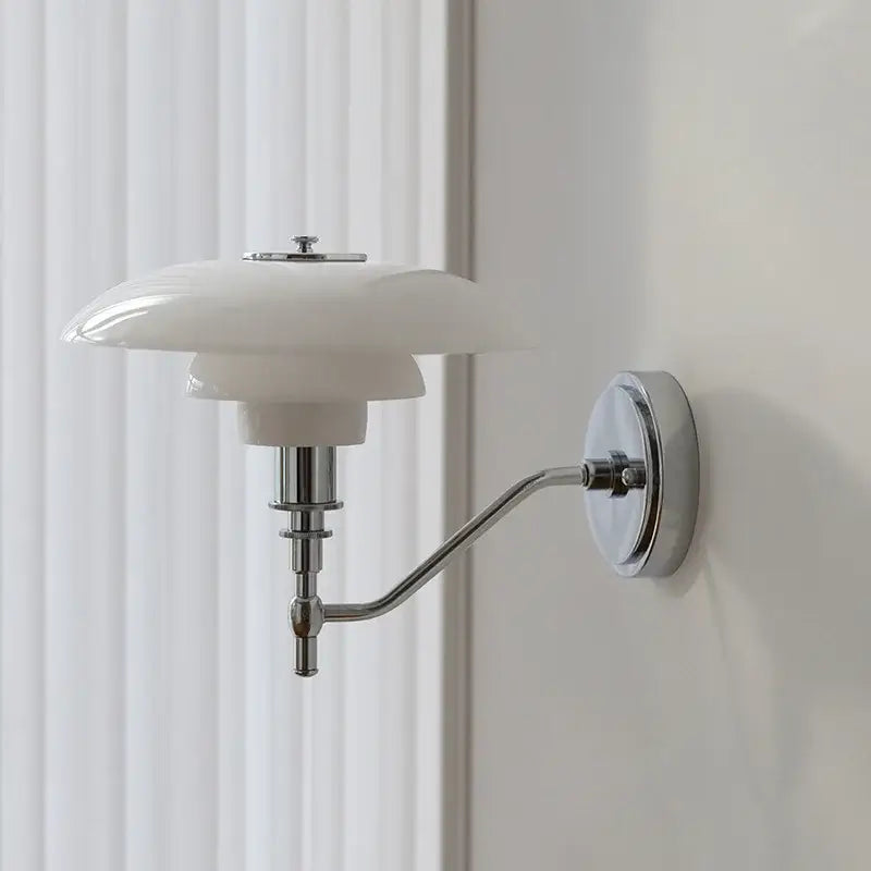 A sleek modern chrome french glass wall lamp with a glossy white ceramic shade and polished metal arm for bedroom decor