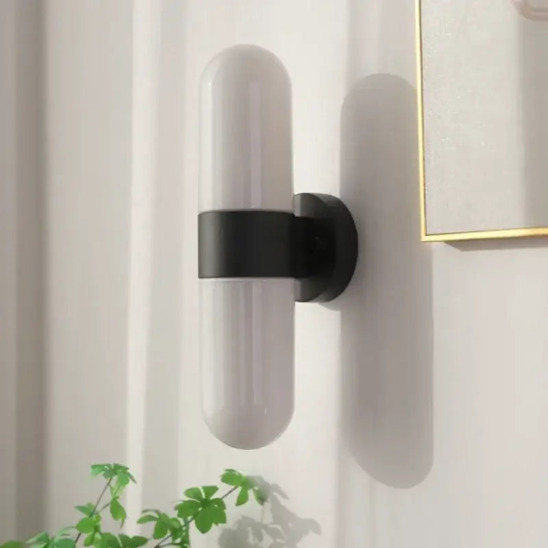 Modern chrome vanity mirror light with frosted glass shade and matte black metal bracket bathroom sconce