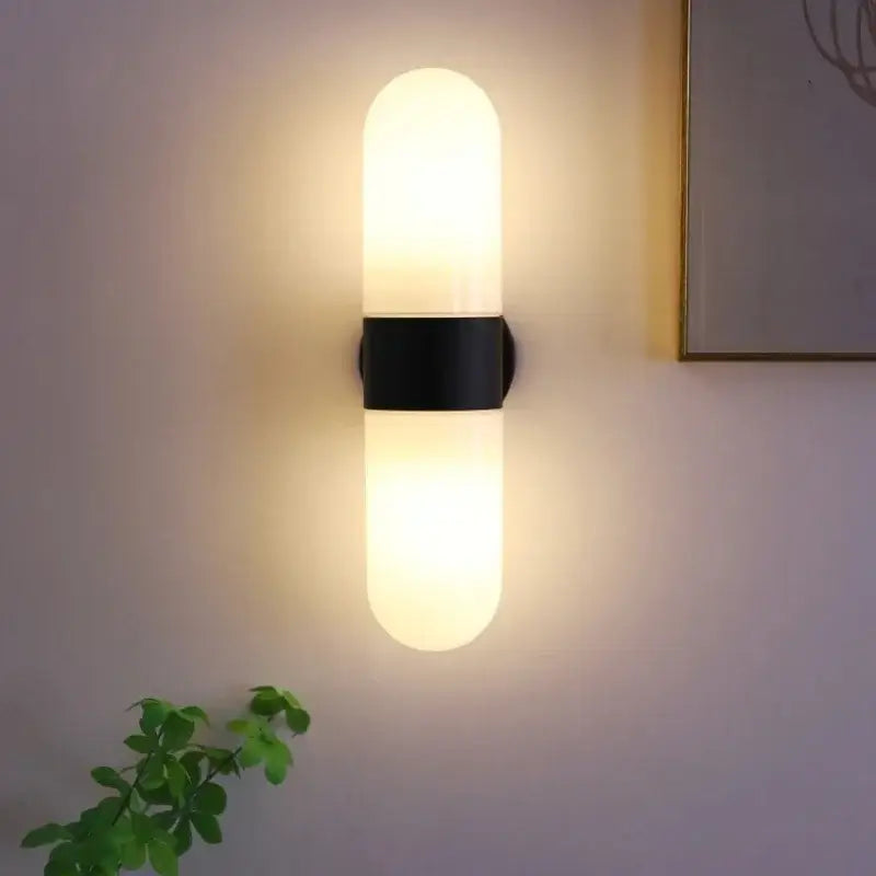 Modern chrome vanity mirror light with frosted glass cylinder and black metal band wall sconce for bathroom use