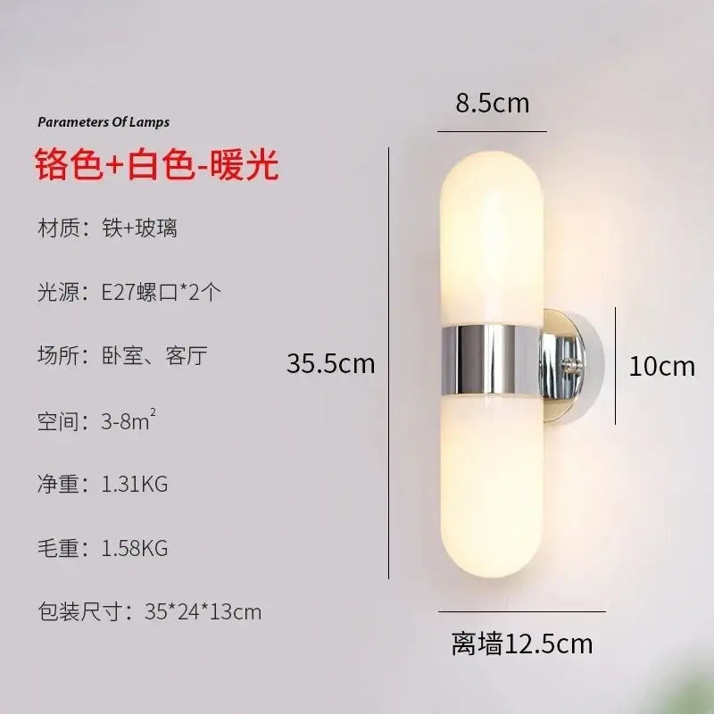 A sleek modern chrome vanity mirror light with brushed finish and two frosted glass shades emitting warm light
