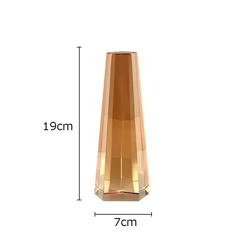 A tall amber faceted glass vase with a tapered shape complementing decorbites geometric crystal artwork polyhedron bookends