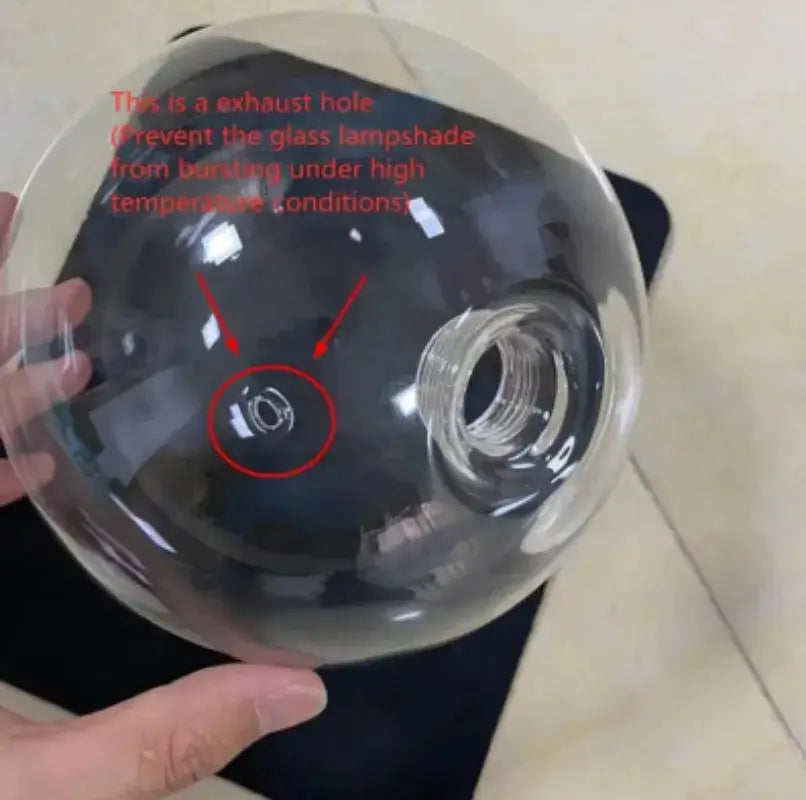Clear glass ball pendant light with central exhaust hole and threaded opening for bulb attachment decorbites glass ball