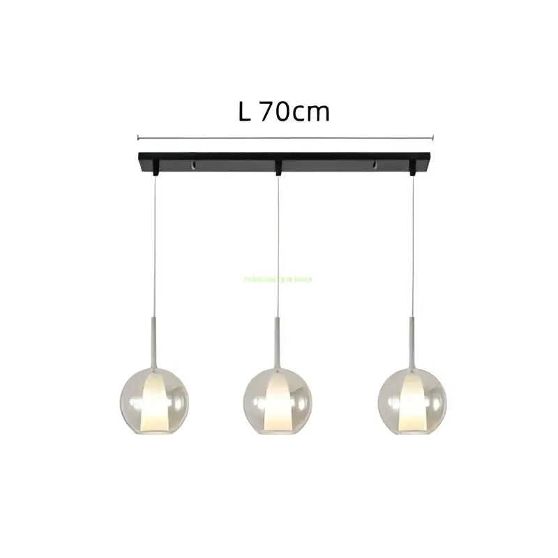 Modern chrome glass bubble pendant lights feature black rectangular bar with three warm glowing glass bubble pendant globes