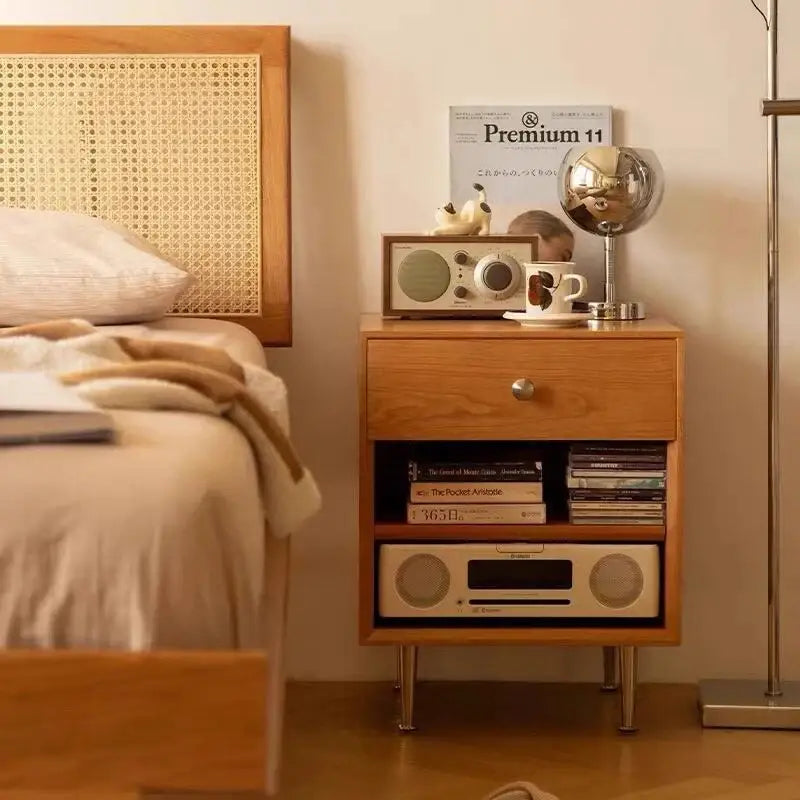 Wooden nightstand with light brown wood grain finish and slender metal legs paired with decorbites glass gold table lamp