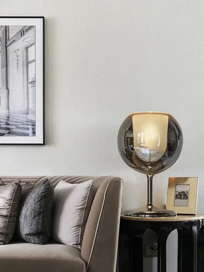 A sleek modern chrome glass gold table lamp with reflective metallic finish and amber glass shade for living room decorbites glass gold