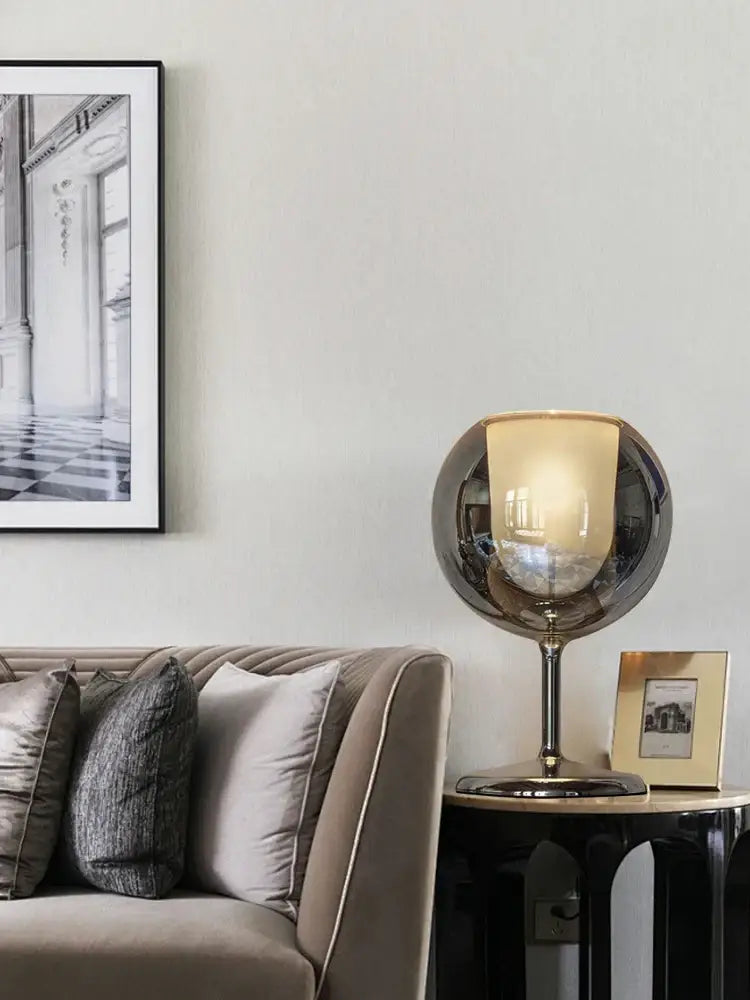 A sleek modern chrome glass gold table lamp with reflective metallic finish and amber glass shade for living room decorbites glass gold