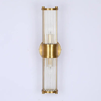 Gold-toned glass rod wall sconce with circular brass accent designed as modern vanity lights for bathroom use