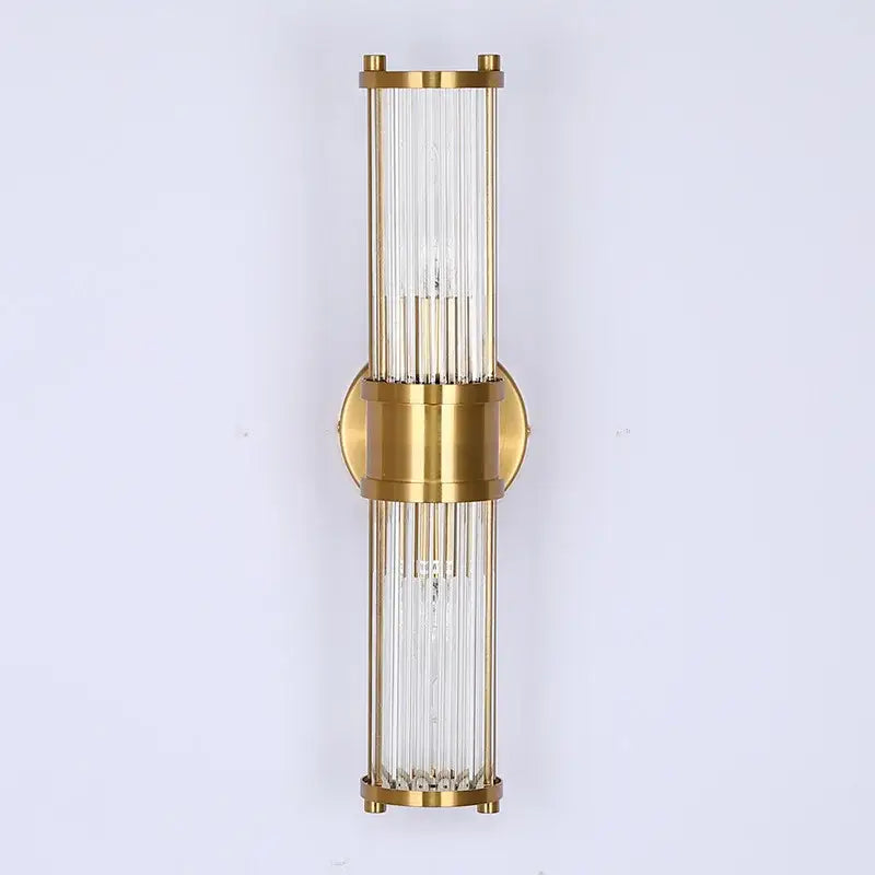 Gold-toned glass rod wall sconce with circular brass accent designed as modern vanity lights for bathroom use