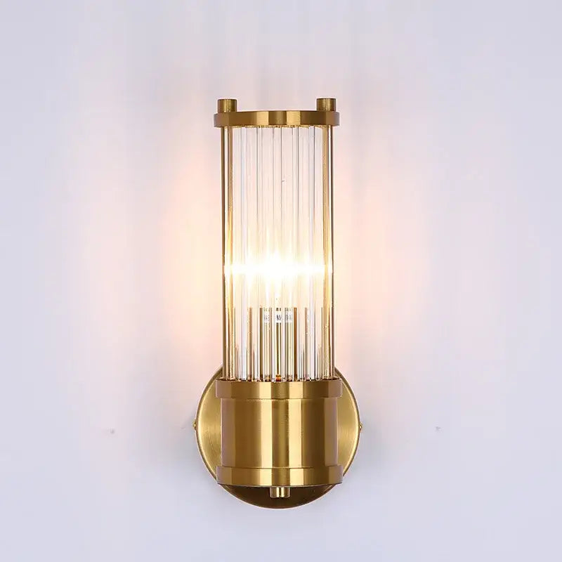 Modern gold-toned rod wall sconce with vertical glass rods and cylindrical brass base for bathroom vanity lights