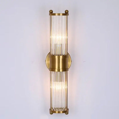Gold-toned glass rod wall sconce with vertical rods and circular mount perfect for modern vanity lights