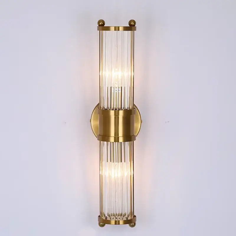 Gold-toned glass rod wall sconce with vertical rods and circular mount perfect for modern vanity lights