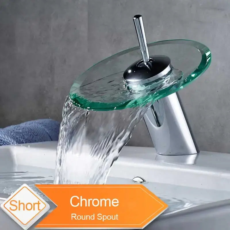 Modern chrome basin faucet with a transparent green glass spout and round waterfall design for bathroom use