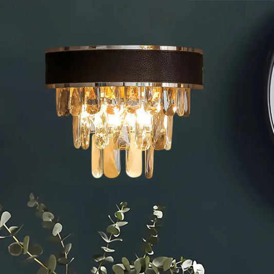 A modern sconce light fixture with black leather band, chrome trim, and cascading golden crystal block teardrops wall lamp