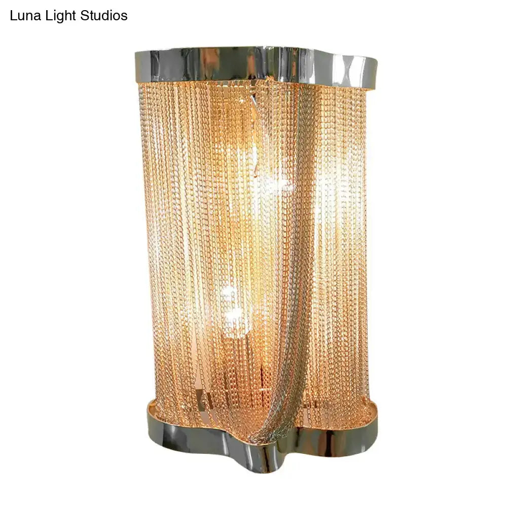Golden chain-link table lamp with sleek chrome base and top complementing modern chrome and gold wall lamp set