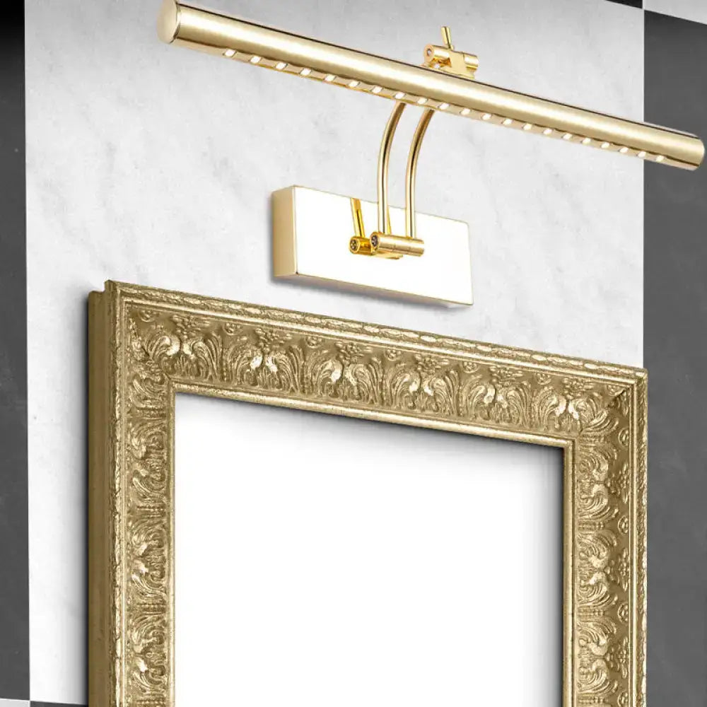 Gold-finished led bathroom wall lamp with chrome gold tubular metal shade and sleek modern design above ornate frame
