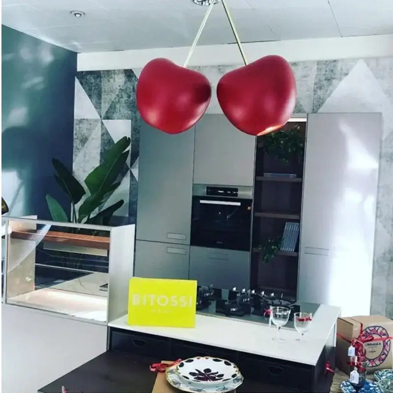 Two glossy red chrome cherry creative light pendant lamps hang from ceiling in modern creative light chandelier decorbites style