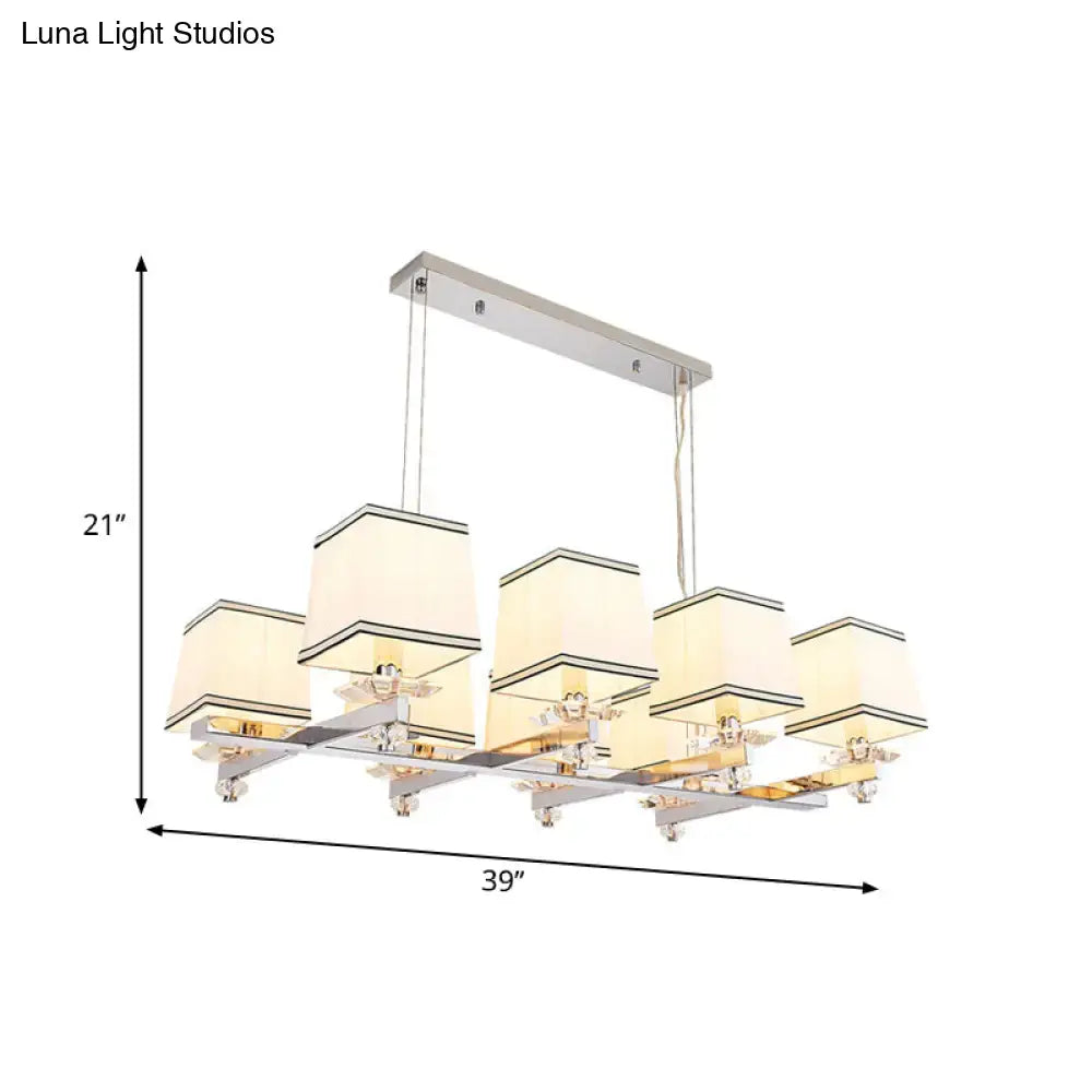 Modern chrome island pendant light with five cream fabric shades and black trim in a sleek chrome frame for dining rooms