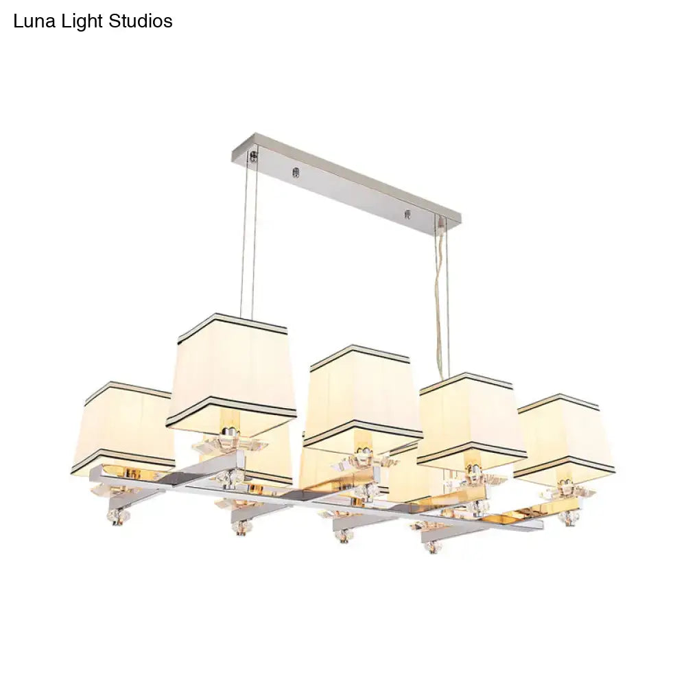 Modern chrome island pendant light with five cream fabric shades and black trim in a polished chrome frame for dining rooms