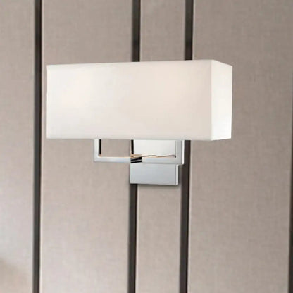 Modern chrome led wall sconce with a sleek chrome finish and white fabric shade for bedroom lighting