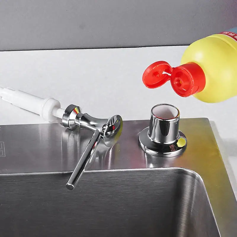 Modern chrome liquid soap dispenser with sleek design and white pump handle for kitchen use
