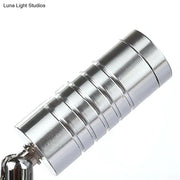 Silver cylindrical magnetic keychain with segmented ribbed design showcasing modern chrome mini tubed wall lamp white warm lighting