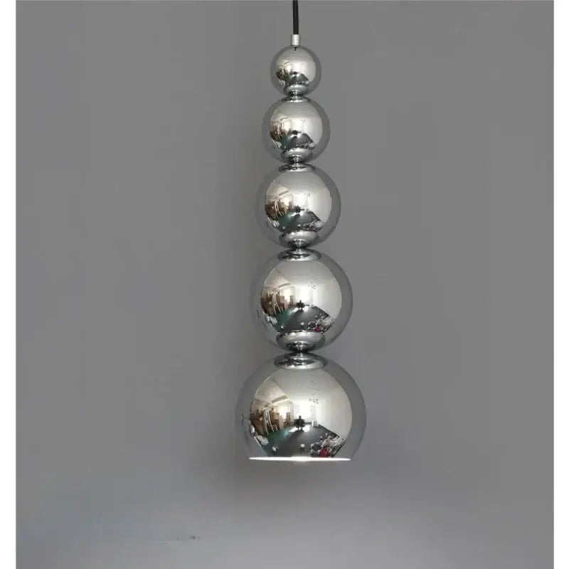 A modern chrome multi ball pendant light with five reflective spherical bulbs as a stylish light source