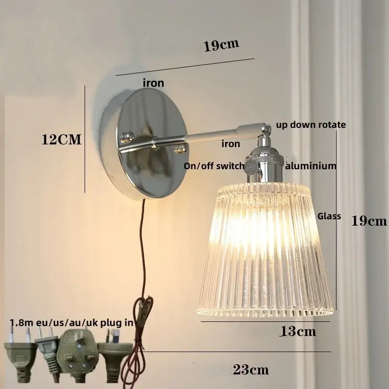 A sleek modern chrome wall lamp with ribbed clear glass shade and polished iron base for bedroom decorbites clear glass