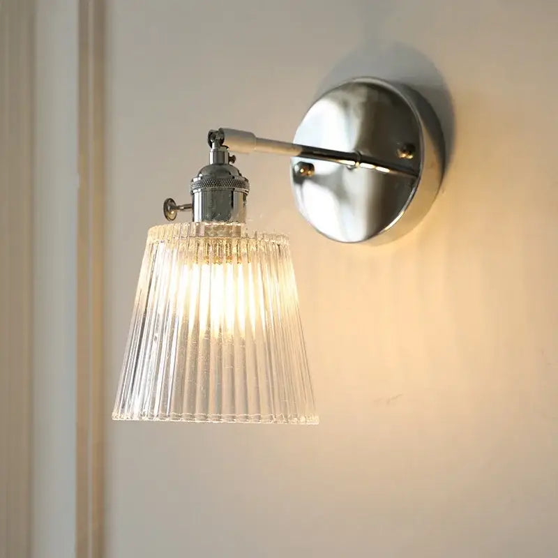 Modern chrome wall lamp with clear ribbed glass shade diffusing warm light for bedroom by decorbites clear glass