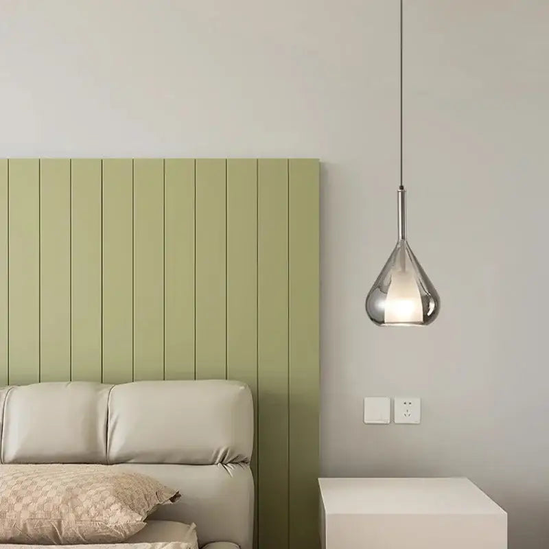 A sleek modern chrome teardrop chandelier pendant light with polished finish hanging suitable for dining room