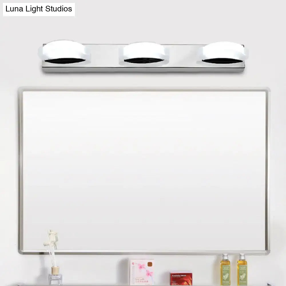 Modern chrome three light vanity mirror light with white frosted globe bulbs and warm color temperature for bathroom use