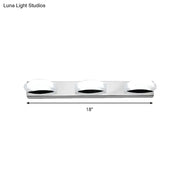 Silver chrome three-light vanity mirror light with frosted white globe shades and warm color temperature for bathroom