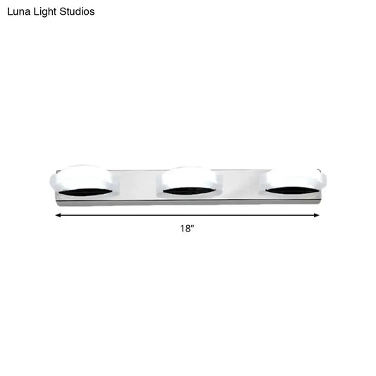 Silver chrome three-light vanity mirror light with frosted white globe shades and warm color temperature for bathroom