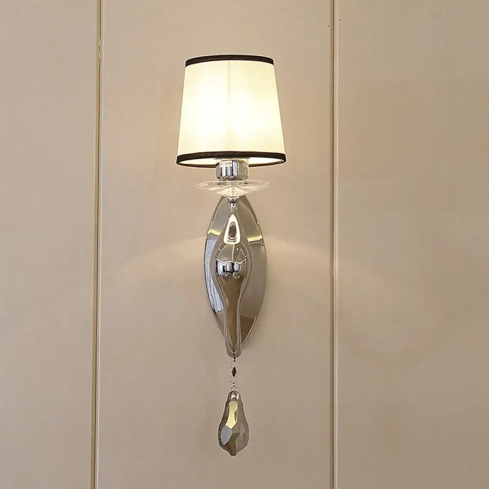 Elegant modern chrome wall lamp with cream fabric shade and dangling crystal pendant for living room use