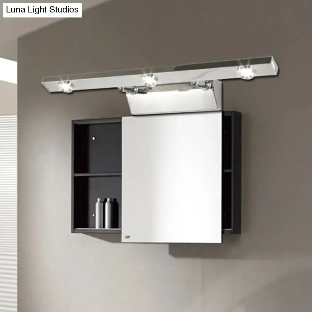 Modern chrome wall light with three adjustable stainless steel shade spotlights above black mirrored medicine cabinet