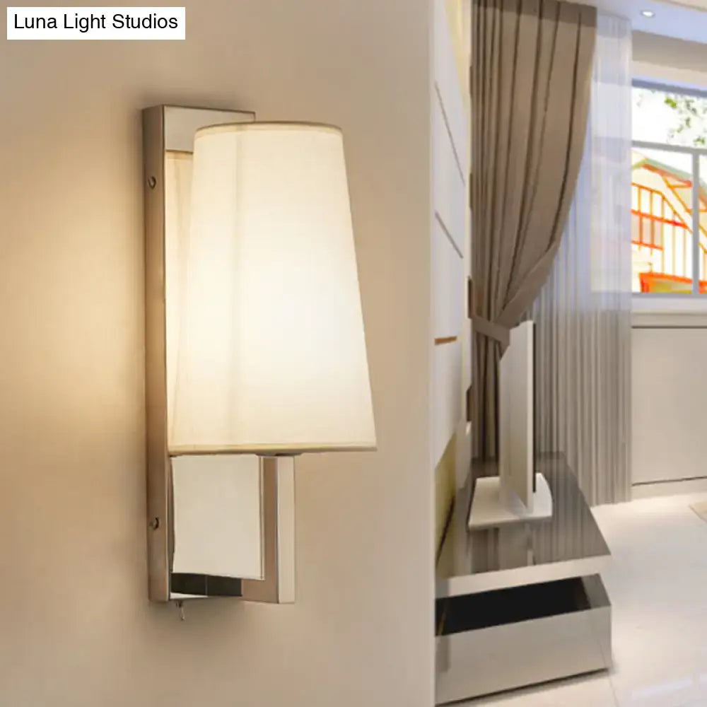 Modern chrome wall sconce light with sleek metallic frame and handmade cone fabric shade for bedroom use