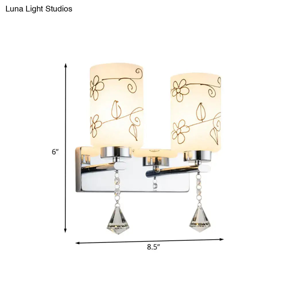 Modern chrome white glass cylinder wall sconce with frosted white glass shades and gold floral etchings for bedroom lighting
