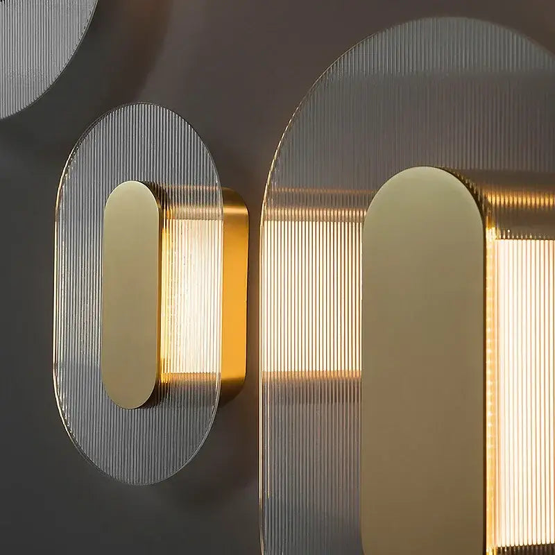 Modern circular brushed metallic wall lamp with gold-toned ribbed glass panels and warm led lighting for elegant glass wall decorbites