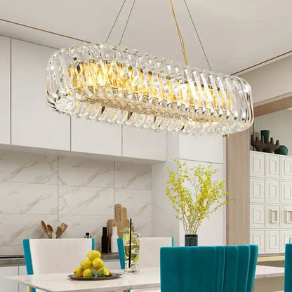 A modern oval-shaped decorbites crystal led ceiling chandelier with gold-toned frame and hanging wires for dining room decor