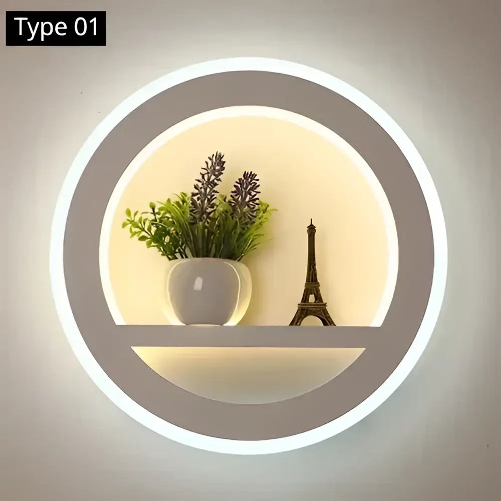 Modern circular dimmable led wall lamp with sleek gray frame, remote control, shelf, white ceramic pot, and miniature eiffel tower